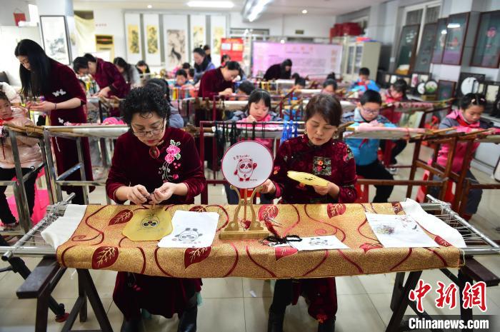 江西省級(jí)非遺豫章繡傳承人手把手指導(dǎo)小學(xué)生繡制2022年北京冬奧會(huì)吉祥物“冰墩墩”形象?！∮髟屏?攝