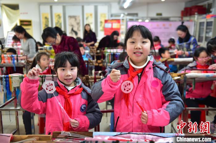 圖為小學(xué)生展示繡制好的2022年北京冬奧會(huì)吉祥物“冰墩墩”形象?！∮髟屏?攝