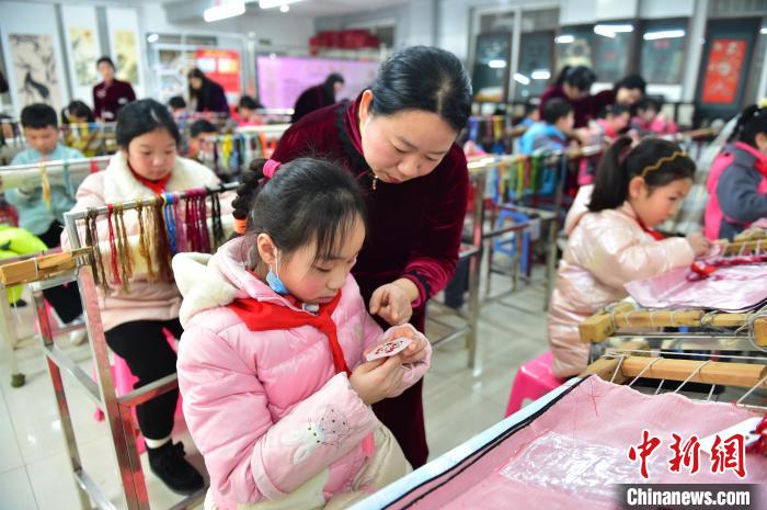 江西省級(jí)非遺豫章繡傳承人手把手指導(dǎo)小學(xué)生繡制2022年北京冬奧會(huì)吉祥物“冰墩墩”形象?！∮髟屏?攝