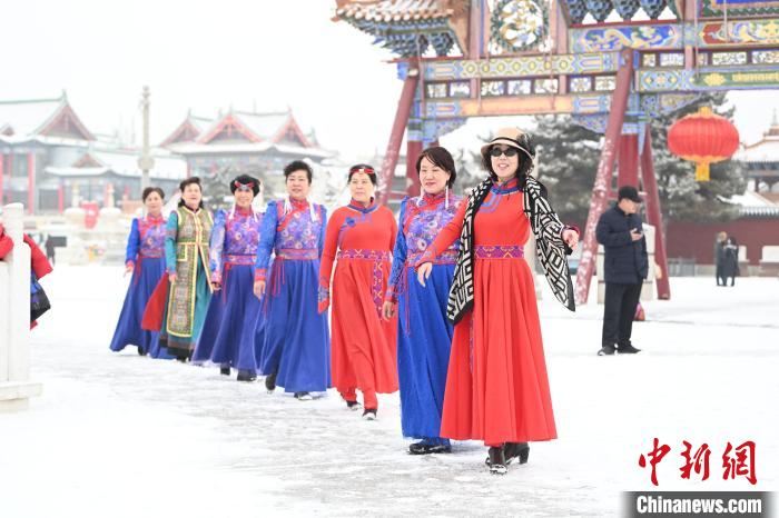 2月13日，老年人在呼和浩特市大召?gòu)V場(chǎng)拍照“打卡”?！⑽娜A 攝