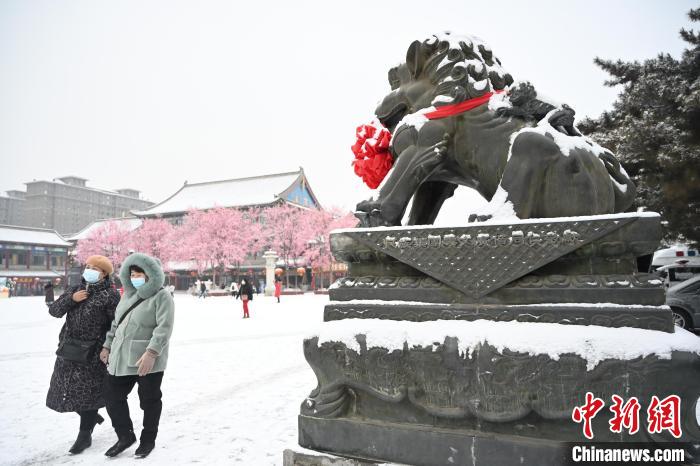 2月13日，民眾在呼和浩特市大召?gòu)V場(chǎng)雪中漫步。　劉文華 攝