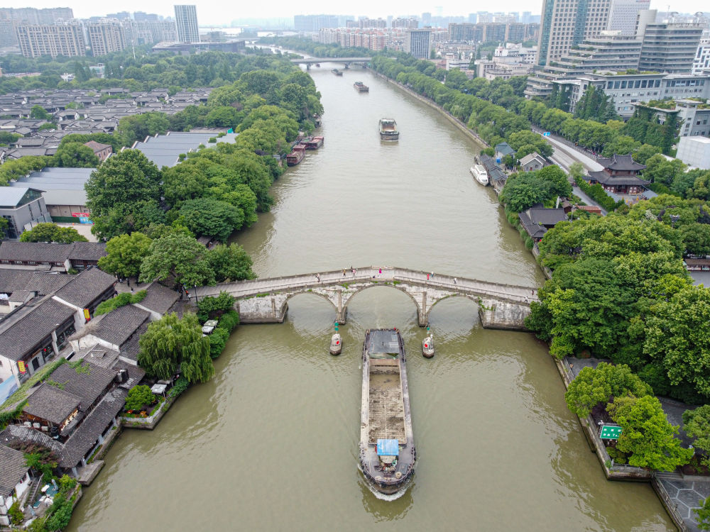 5月27日，一艘貨船駛過京杭大運河南端標(biāo)志建筑杭州拱宸橋。(無人機照片)新華社記者江漢 攝