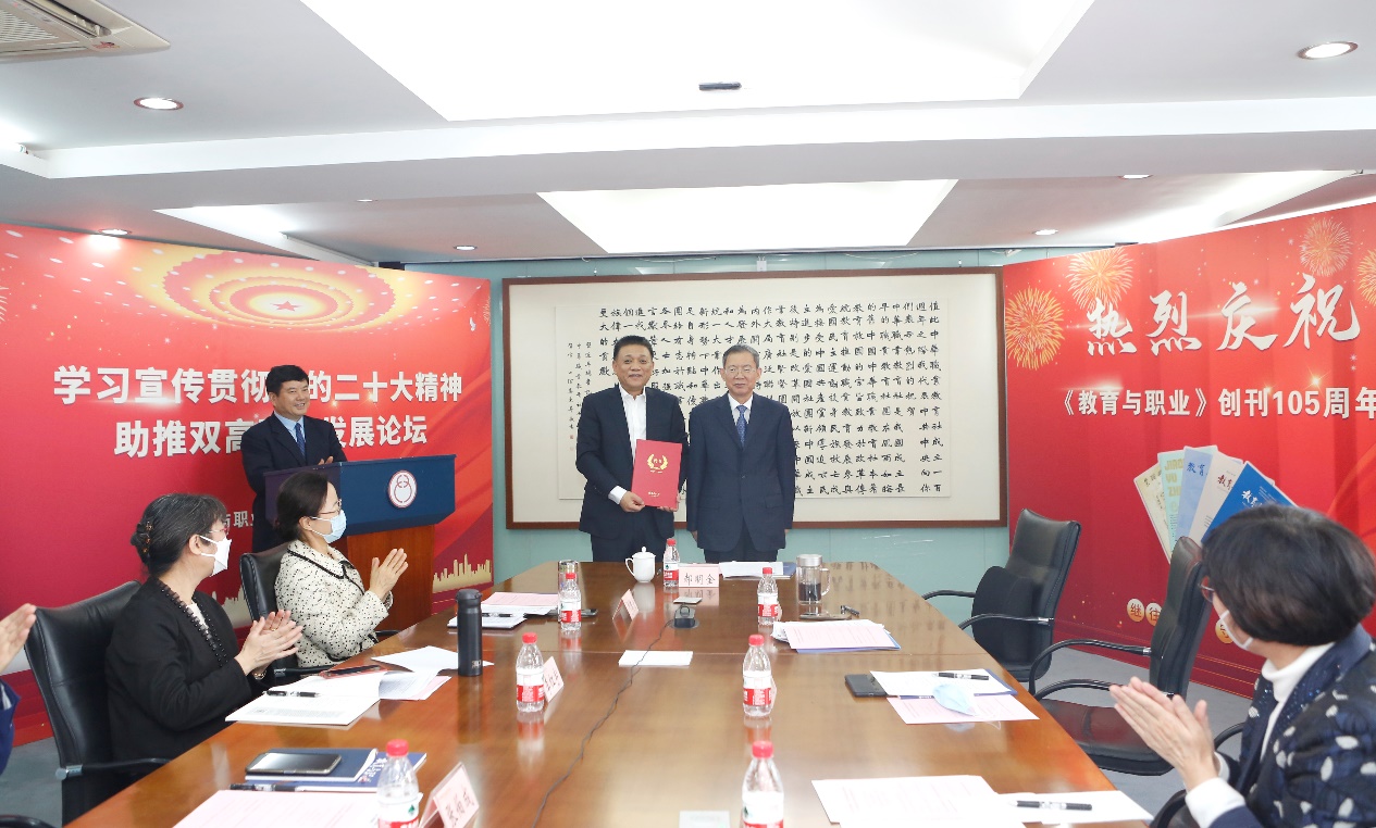 郝明金為《教育與職業(yè)》雜志編委代表陳曉明頒發(fā)聘書。中華職教社供圖