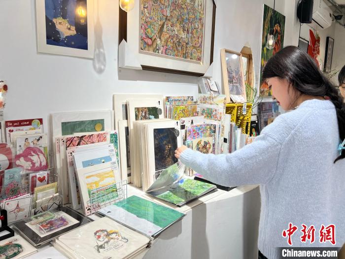 圖為藝術品商店內，顧客挑選插畫作品?！＄婌?攝