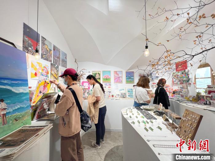 圖為藝術品商店內，顧客挑選插畫作品?！＄婌?攝