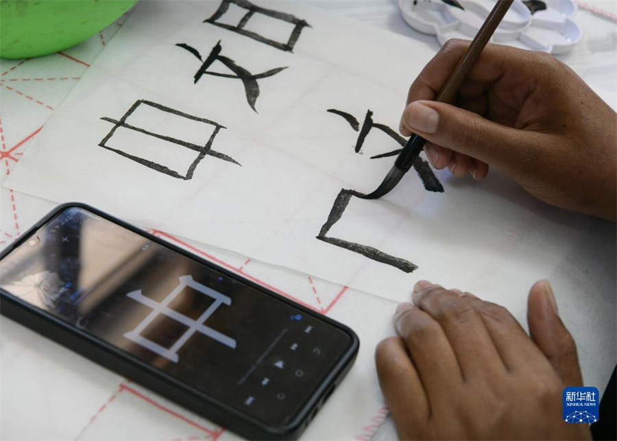 4月18日，肯尼亞學(xué)生在內(nèi)羅畢大學(xué)孔子學(xué)院舉辦的活動上寫毛筆字?？夏醽唭?nèi)羅畢大學(xué)孔子學(xué)院18日舉辦“中文，增進文明對話”主題活動，慶祝即將到來的第14個聯(lián)合國中文日?？夏醽唽W(xué)生參與互動，進行書法、剪紙、唱中文歌等活動。新華社記者 韓旭 攝