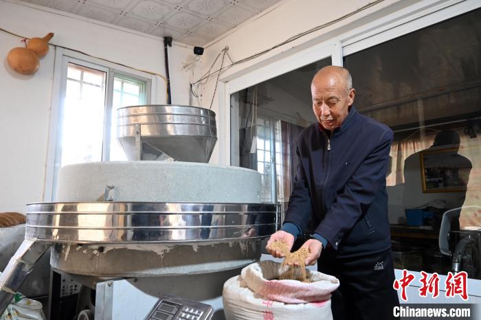 李家莊村民谷文朝重拾父輩的手藝，做起石磨面粉的營生?！〉杂鸺?攝