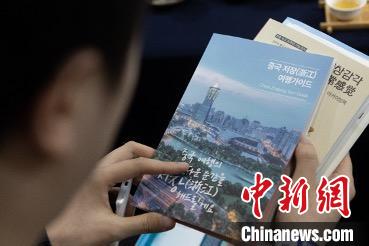 參展觀眾閱讀浙江文旅手冊?！《≌裾?攝