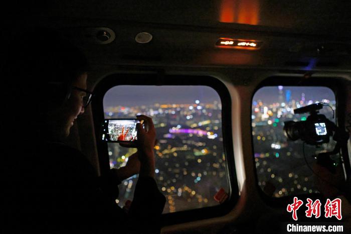 6月3日晚，游客乘坐上海新空直升機(jī)有限公司直升機(jī)開啟鳥瞰黃浦江空中圓夢(mèng)之旅，并用手機(jī)拍攝城市夜景?！∫罅⑶?攝