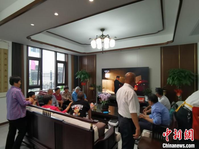 親友們集中在費(fèi)俊龍家中觀看返程的視頻?！＄娚?攝