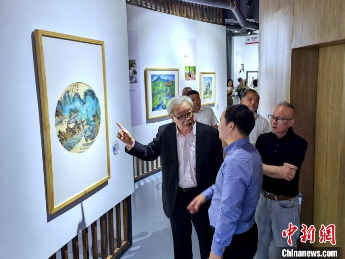 海峽兩岸藝術(shù)家畫展上，藝術(shù)家進(jìn)行藝術(shù)交流?！「毒窜?攝