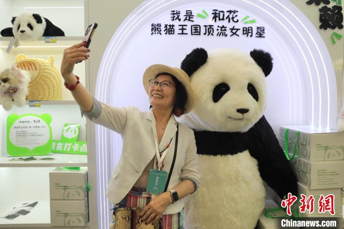 美國華視總裁楊蓮花與大熊貓文創(chuàng)產(chǎn)品合影?！⊥趵?攝