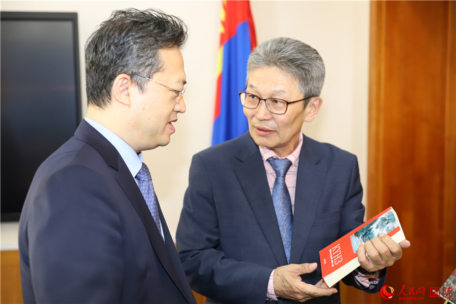 其米德策耶（右一）向李峙介紹翻譯成果。人民網(wǎng)記者 霍文攝