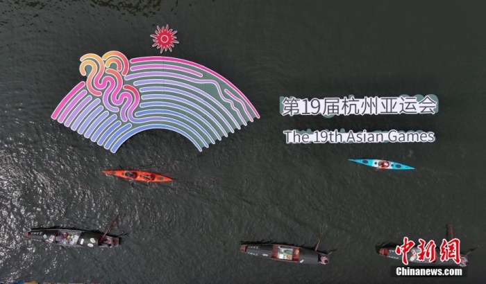 資料圖為烏篷船和皮劃艇從杭州亞運會標識前劃過。王剛 攝