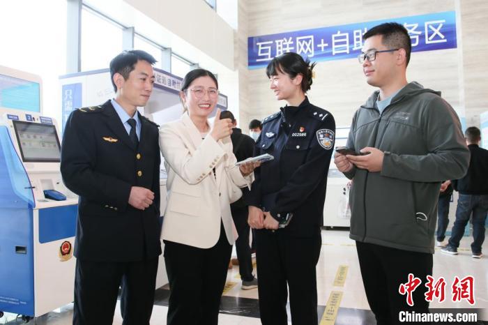 4月10日，安徽合肥，一家運輸企業(yè)負責人在工作人員的指導下，使用小程序辦理車管業(yè)務。　合肥警方供圖