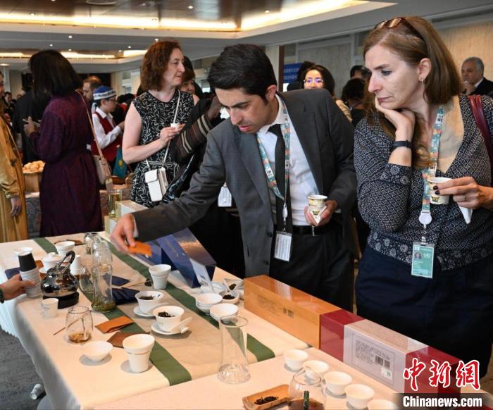 現(xiàn)場觀眾觀看中國展臺茶藝表演、了解茶文化。　靖樹 攝