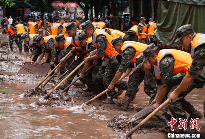 7月4日，萬州區(qū)五橋街道，武警官兵清理街道上的淤泥。　冉孟軍 攝