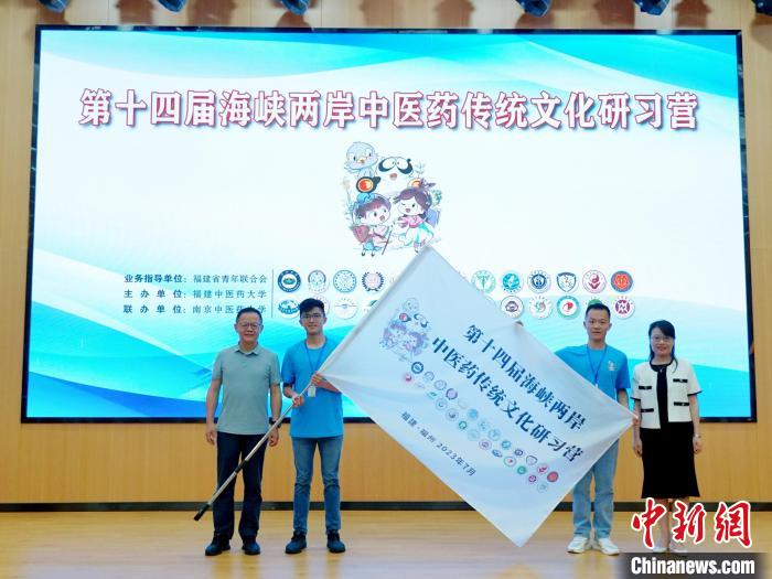 共青團(tuán)福建省委副書記吳雪(右一)、福建中醫(yī)藥大學(xué)黨委副書記林羽(左一)為兩岸學(xué)生代表頒授營旗?！≡S燁婷 攝