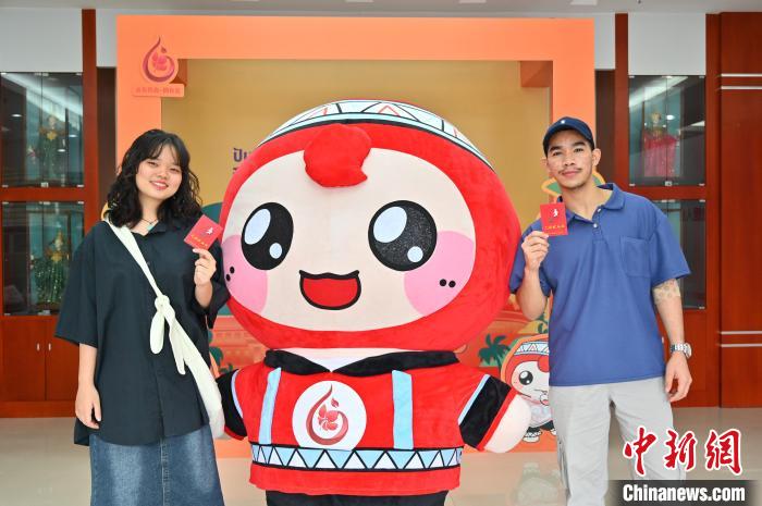 圖為泰國留學(xué)生手持獻血證與人偶合影。　俞靖 攝