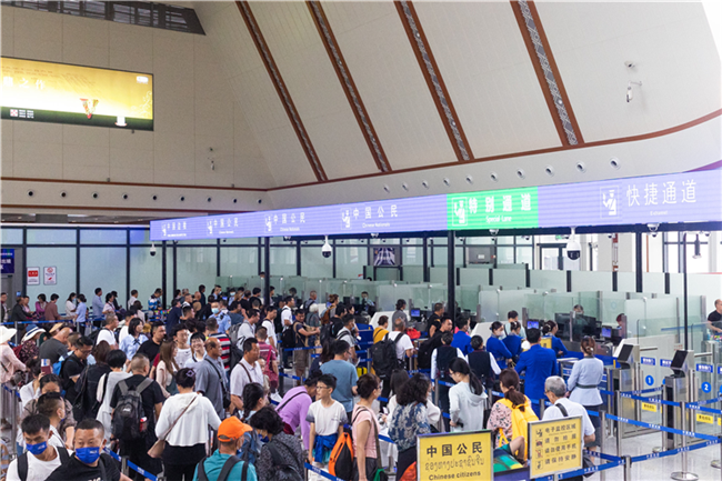 7月22日，乘坐中老鐵路國際旅客列車的旅客在磨憨邊檢大廳排隊(duì)候檢。衛(wèi)海林 攝