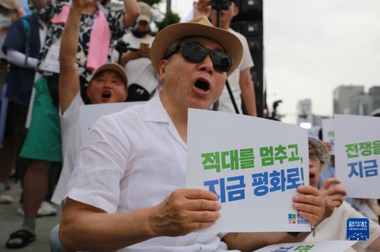 7月22日，在韓國首爾，人們手舉標語參與反戰(zhàn)游行。新華社發(fā)（楊暢 攝）