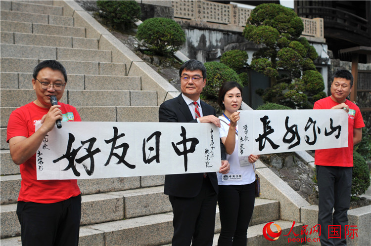 東京中國(guó)文化中心主任羅玉泉展示其為本次活動(dòng)書寫的題詞“中日友好，山高水長(zhǎng)”。人民網(wǎng) 蔣曉辰攝