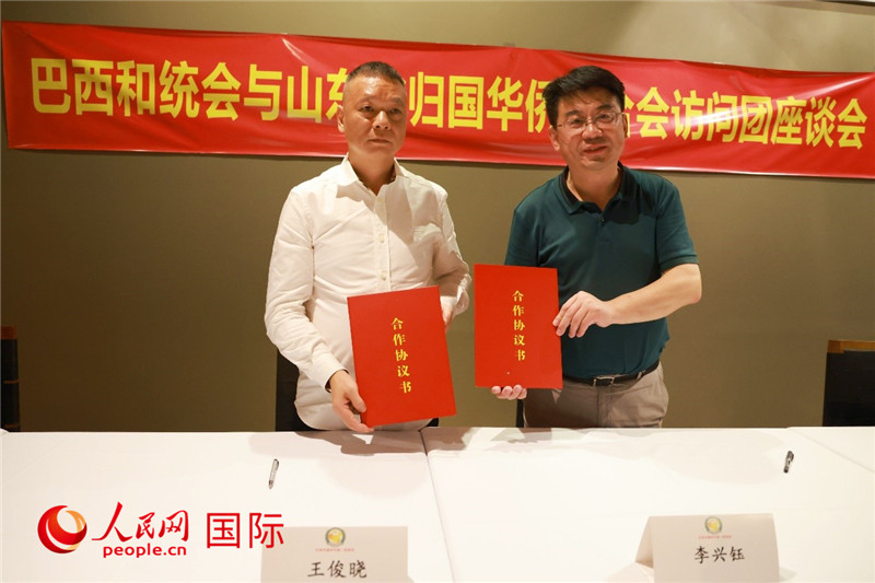 中國(guó)僑聯(lián)副主席、山東省僑聯(lián)主席李興鈺（右）與巴西和統(tǒng)會(huì)會(huì)長(zhǎng)王俊曉簽署合作協(xié)議書。人民網(wǎng)記者 陳海琪攝