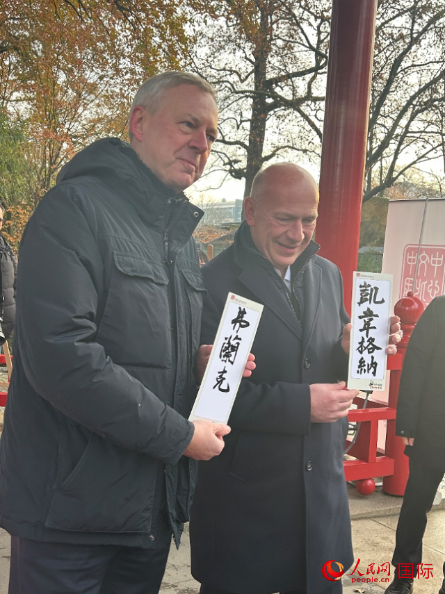 柏林市長(zhǎng)韋格納（右）、動(dòng)物園監(jiān)事會(huì)主席布魯克曼（左）手持中國(guó)文化中心工作人員現(xiàn)場(chǎng)手書的中文名字。人民網(wǎng)記者 徐馨攝