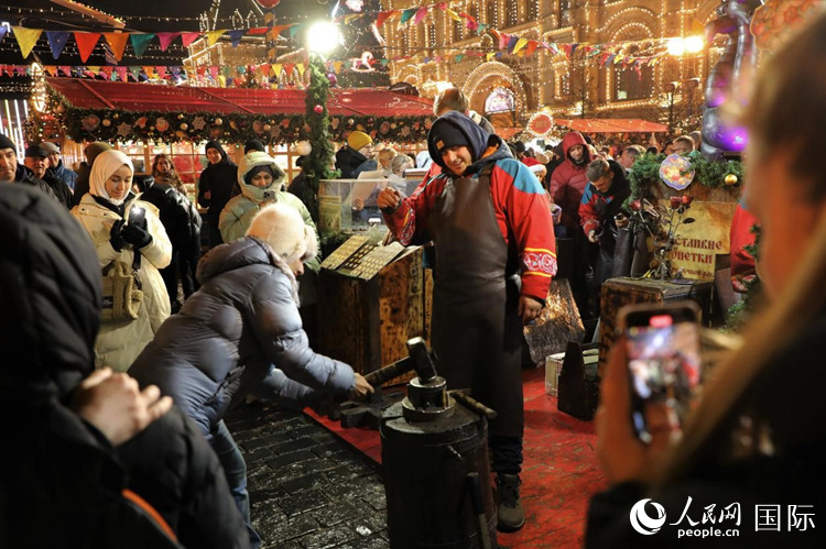 游客在新年集市上體驗制作紀(jì)念幣。人民網(wǎng)記者 隋鑫攝