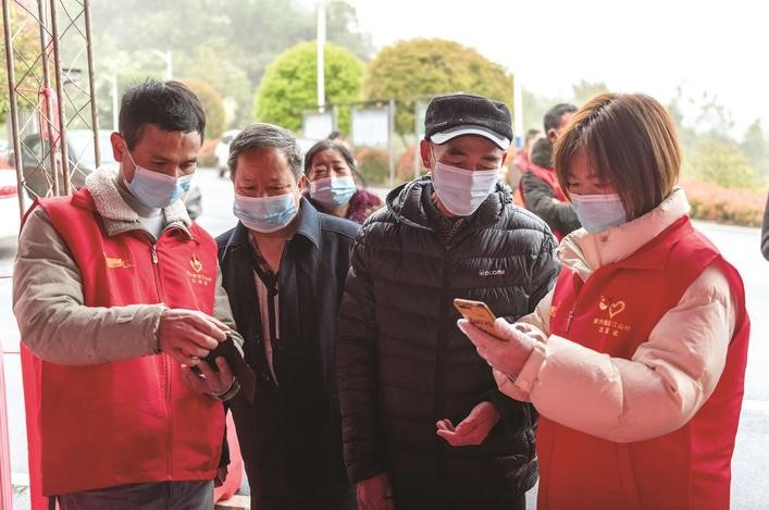 長沙縣黨員志愿者正在幫助參與核酸檢測的群眾掃描“場所碼”。劉思源 攝