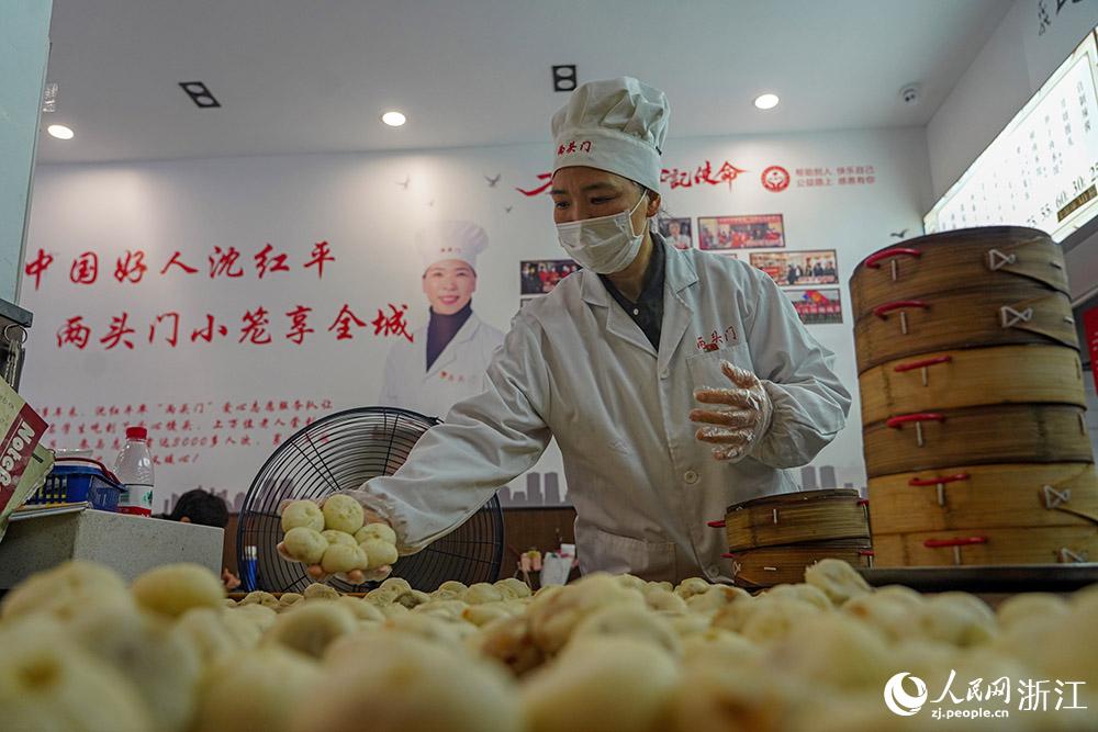 3月31日，在浙江省嵊州市甘霖鎮(zhèn)，嵊州小吃從業(yè)者沈紅平把蒸熟的小籠包晾涼，打包冷藏售賣。人民網(wǎng) 章勇濤攝