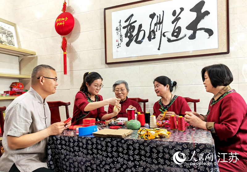 王秀英老人指導(dǎo)孫女制作香包。人民網(wǎng) 閆峰攝