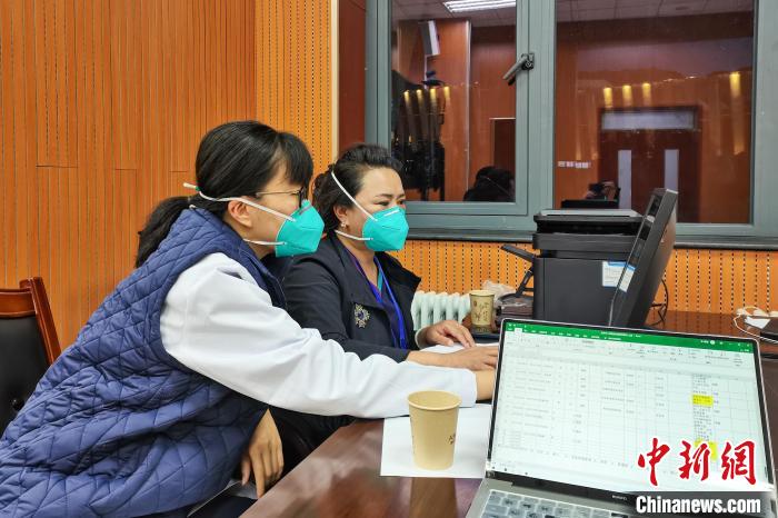 8月9日，楊蘇喬(左)在拉薩方艙醫(yī)院指揮部讀取艙內(nèi)患者胸部CT。　受訪者供圖