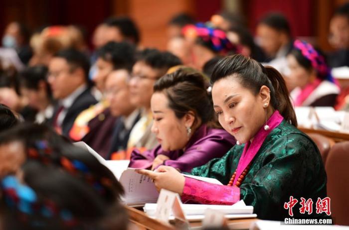 1月5日，次旦卓嘎(右一)在拉薩參加西藏自治區(qū)第十一屆人民代表大會第五次會議第二次全體會議。西藏自治區(qū)人大代表次旦卓嘎來自日喀則市定日縣，定日縣被稱為“洛諧故鄉(xiāng)”，作為西藏民間歌舞，洛諧已被列入中國國家非物質(zhì)文化遺產(chǎn)項目名錄，這是集歌、舞、樂、彈唱于一體的綜合藝術形式。參加完西藏2022年新年音樂會的次旦卓嘎告訴記者，每年參加的基層演出可達80場，“我希望用最純粹的方式，把最好的聲音帶到西藏乃至中國的各個角落。” <a target='_blank' href='/'><p  align=