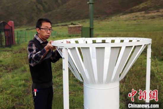圖為班瑪縣氣象局工作人員在維護藏雪茶基地氣候站。青海省氣象局供圖