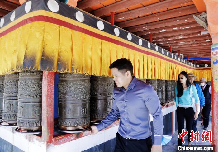 圖為外籍嘉賓體驗藏族傳統(tǒng)轉經筒?！●R銘言 攝