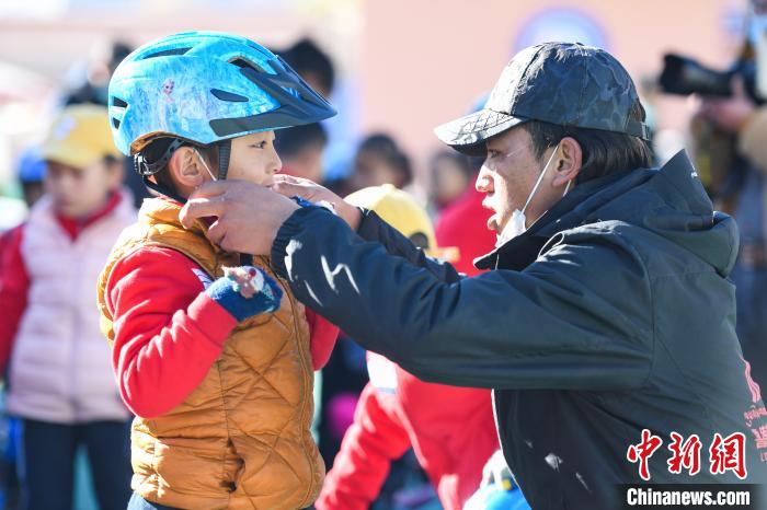 圖為拉薩市實(shí)驗(yàn)幼兒園孩子在教練的幫助下穿戴頭盔。　何蓬磊 攝