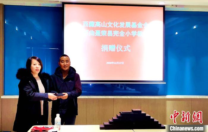 圖為西藏高山文化發(fā)展基金會理事長溫麗向聶榮縣完全小學(xué)負責人捐助儀器。　于賓 攝
