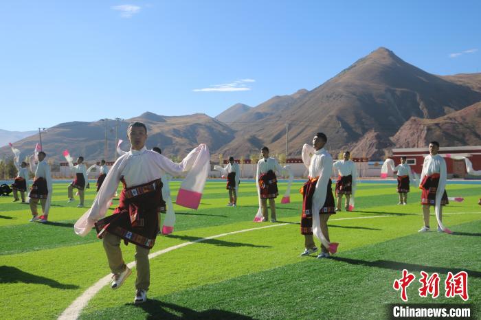 圖為青海師范大學(xué)附屬玉樹實驗學(xué)校學(xué)生在綠茵場跳起囊謙古舞—卓根瑪?！〕逃?攝