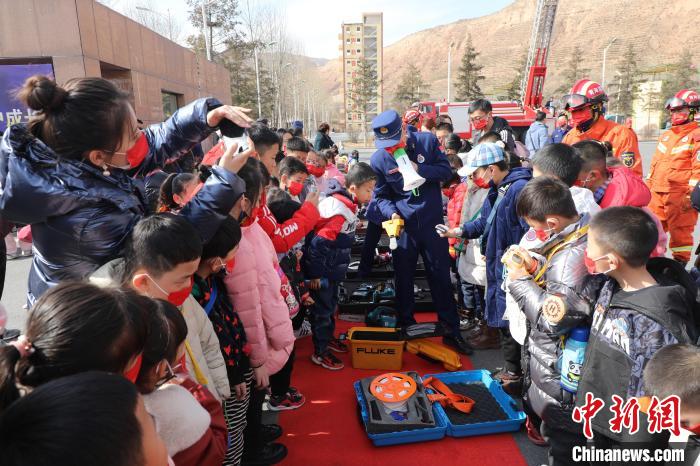 圖為小朋友們聽(tīng)消防員講解消防器材?！铨埥?攝