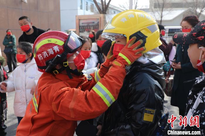 圖為小朋友體驗試穿消防滅火防護(hù)服。　楊龍建 攝