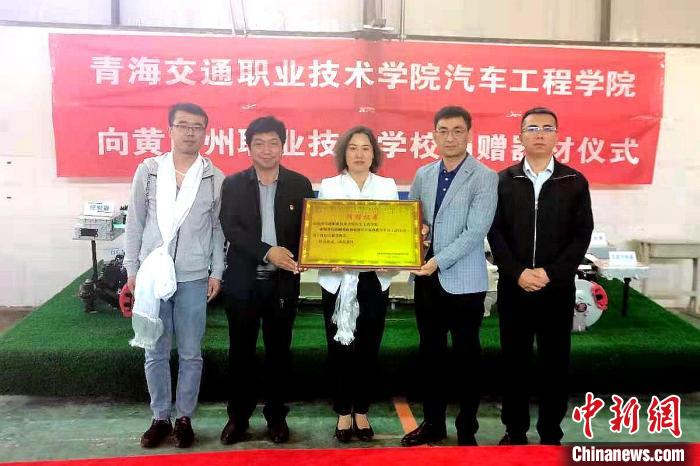 圖為李富香(中)代表學(xué)校為州縣技校捐贈(zèng)器材。(資料圖) 青海省教育廳供圖