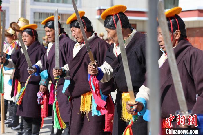 圖為藝人們手持藏刀表演加麻百·甲江?！愔闈扇?攝