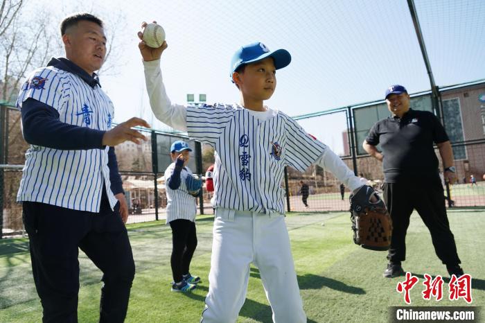 圖為教練指導(dǎo)小棒球手?jǐn)S球技術(shù)?！●R銘言 攝