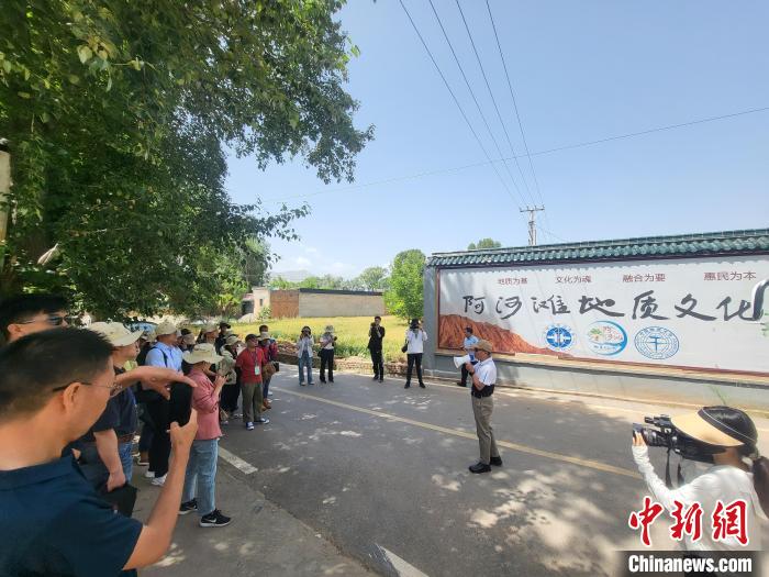 圖為中國(guó)地質(zhì)大學(xué)(北京)教授張緒教介紹村落情況?！『衍?攝