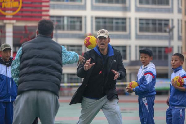 在高原上教孩子們打手球，“慢慢兒來，甭著急！”