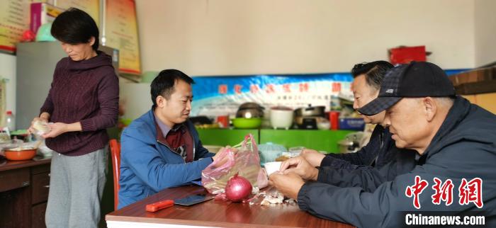 圖為扶貧路上“臨時一家人”準(zhǔn)備午餐?！∥航ㄜ?攝