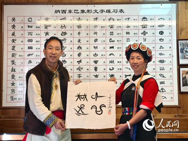 人民網(wǎng)“行進中國”云南調(diào)研采訪團走進麗江，和閏元現(xiàn)場用東巴文寫下“行進中國”。人民網(wǎng)記者 符皓攝