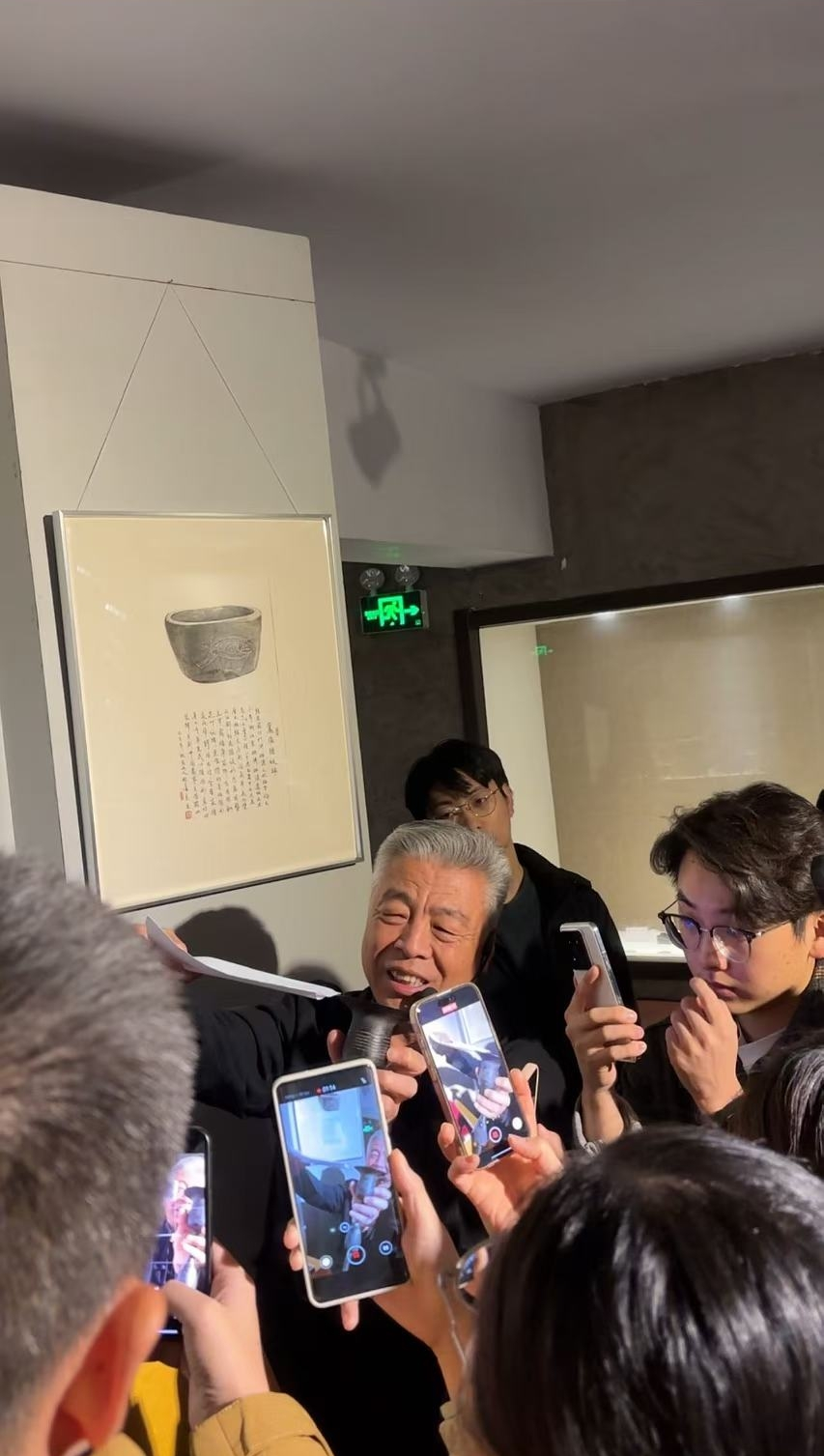黑陶邢文化博物館館長邢葆東展示兩張相疊的A4紙，向記者解釋此為杯口的厚度。