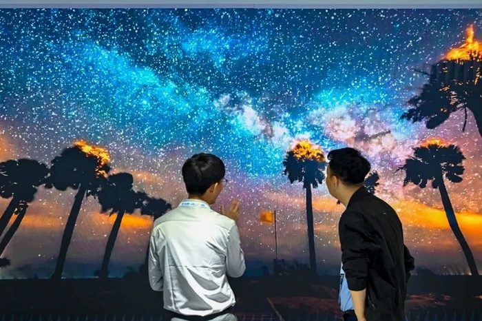 長春光博會(huì)希達(dá)電子展區(qū)，一位工作人員正在給一位觀眾講解。（長春新區(qū)供圖）